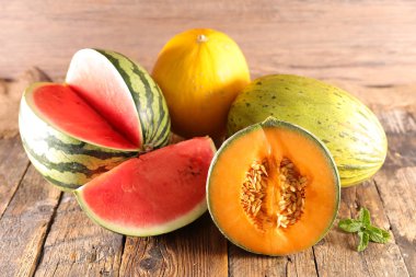 variety of melons and watermelons on wooden background clipart