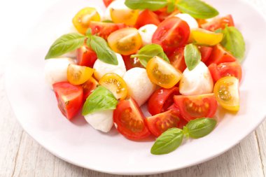 ahşap masa arka plan üzerinde domates, mozzarella ve fesleğen salata