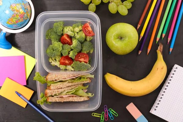 school lunch box on table among stationery