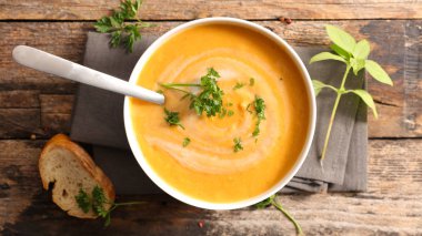 Kremalı sebze çorbası, ahşap masa üzerinde ekmek ile