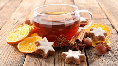 Çay ile fındık, tarçın ve portakal dilimleri ahşap arka plan üzerinde