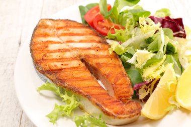 İştah açıcı ızgara somon steak salata beyaz plaka üzerinde