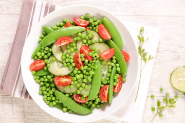 Yeşil bezelye, salatalık ve domates ile parlak sebze salatası