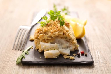 Balık fileto otlar, limon ve çatal taş plaka üzerinde