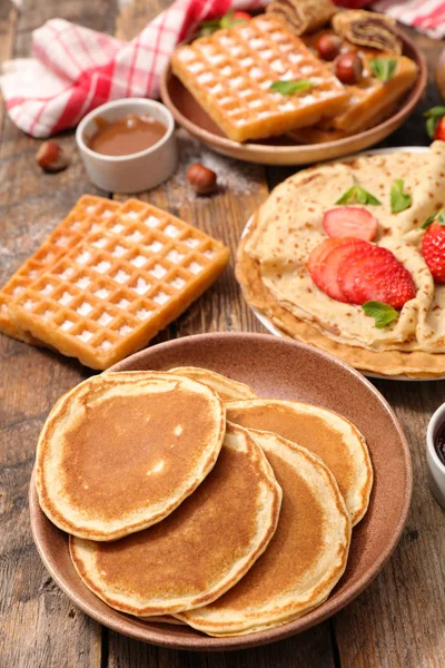 Sweet pancakes, waffles with fruits, chocolate and jam