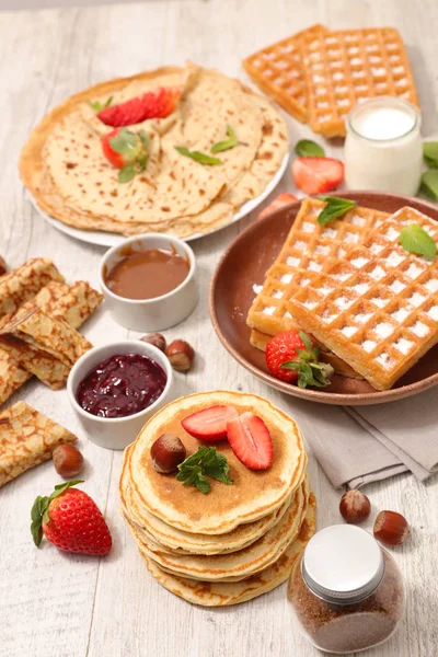 Sweet pancakes, waffles with fruits, chocolate and jam