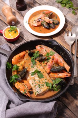 Balık çorbası ve ahşap masanın üzerine sos