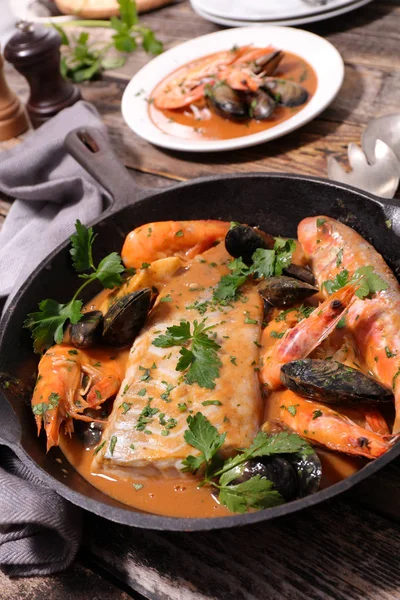 Balık çorbası ve ahşap masanın üzerine sos