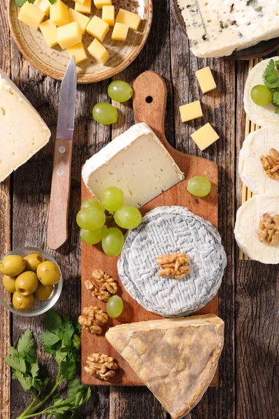variety of cheese on wooden board
