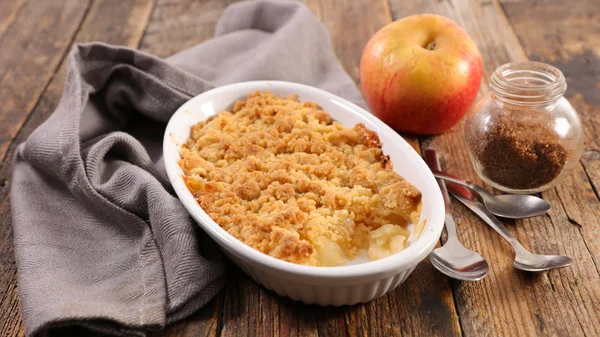 Ceramic pan of apple crumble pie on wooden rustic table