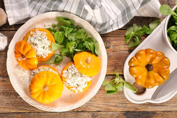 緑の葉とテーブルの上のご飯詰めオレンジ カボチャ — ストック写真