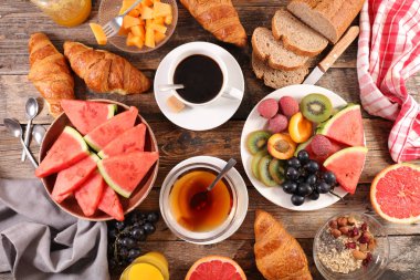 kahvaltı masası ile çay, kahve, kruvasan ve meyve, üstten görünüm