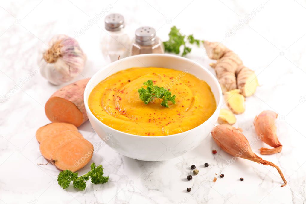 Sweet potato soup with ginger root and garlic on table