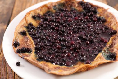 ahşap masa üzerinde plaka ile lezzetli blueberry omlet görünümü kadar kapatın