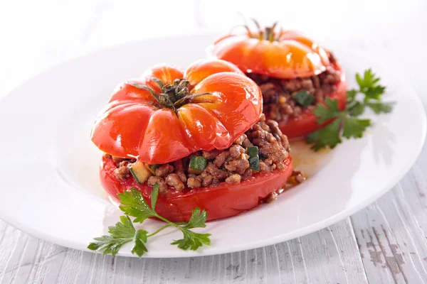 stuffed tomato with minced beef on wooden table