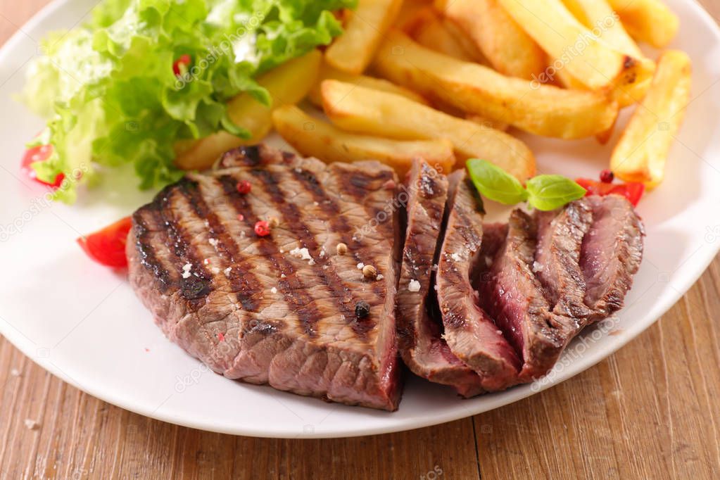 close-up view of grilled beef and french fries