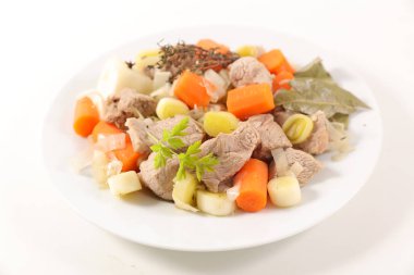 Beyaz tabakta havuç ve pırasa ile Dana