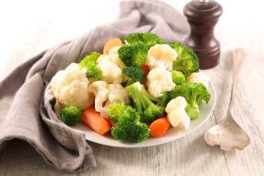 kaşık ile tabağa haşlanmış sebze 