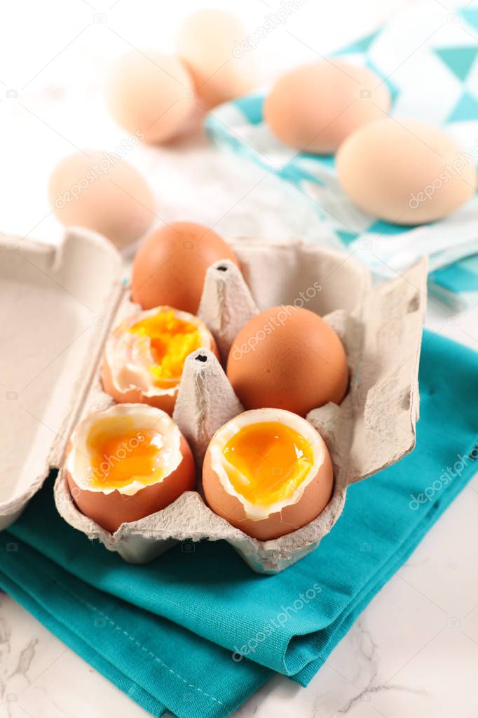 boiled eggs in cardboard box on table with napkin