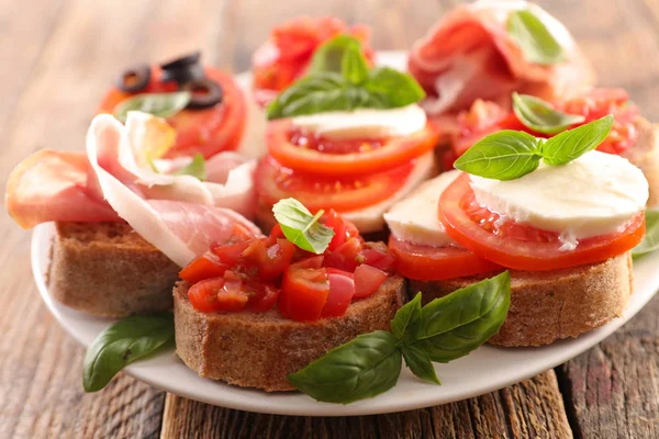 Bruschettas Tomato Ham Mozzarella Basil — Stock Photo, Image