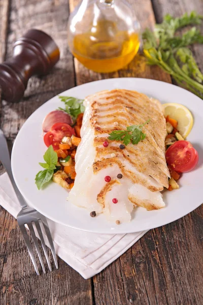 Close up of cooked fish filet with vegetables