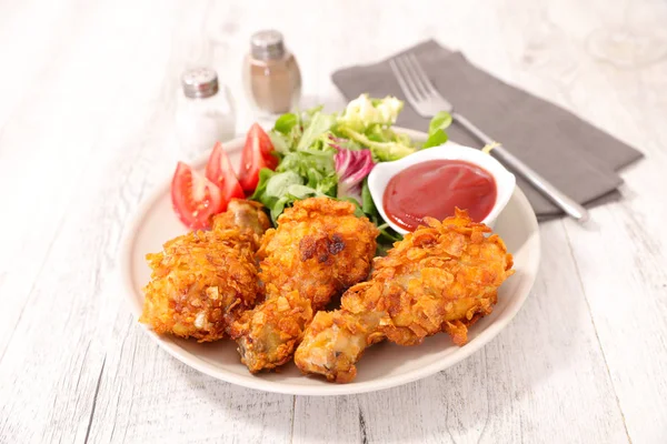 crispy chicken leg with salad and ketchup