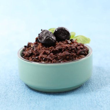 mavi arka plan üzerinde siyah zeytin tapenade