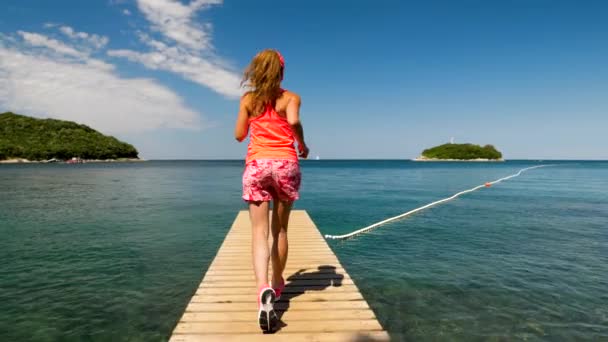 海にポンプーンで走っている女性 スローモーション — ストック動画