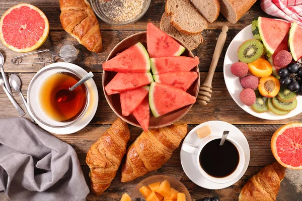 kahve fincanı, çay bardağı, kruvasan ve meyve ile kahvaltı