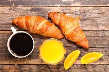 Kahve fincanı, kruvasan ve portakal suyu.