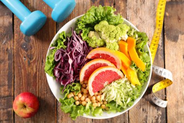 sebze salatası, dambıl ve metre bant ile diyet gıda konsepti
