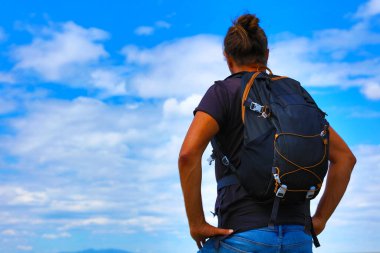 Sırt çantalı adam - gezgin, mavi gökyüzünde maceracı