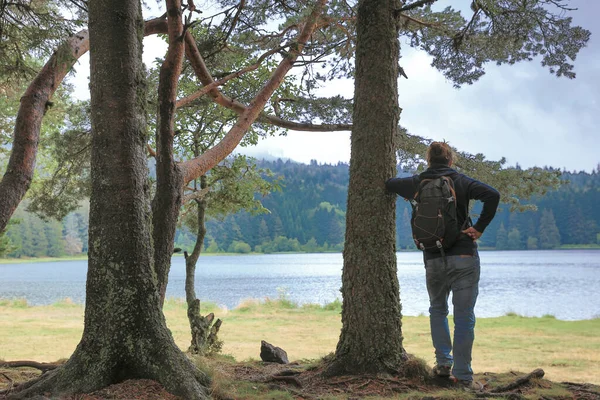 Человек Рюкзаком Лесу Смотрит Озеро — стоковое фото