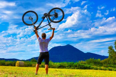 Güzel manzara ve dağın arkasında bisiklet tutan adam, Puy de Dome... Başarı, başarı ve meydan okuma konsepti