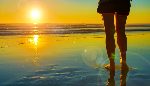 ビーチで女性の足 日没時にビーチを歩く — ストック写真