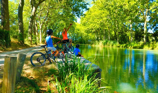 happy family biking along of river- Canal du Midi-France