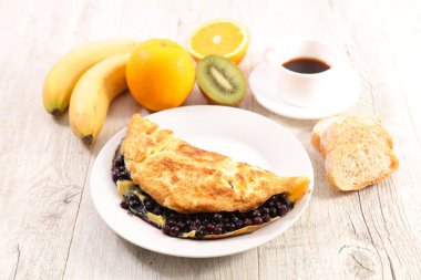 Yabanmersinli omlet, meyve ve kahve fincanı.