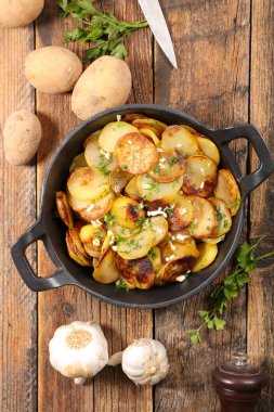 Izgara patates, sarımsak ve otla dilimlenmiş.