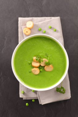 Bir kase bezelye çorbası ve kızarmış ekmek.