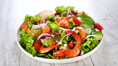 Marul, domates ve soğanlı karides salatası.