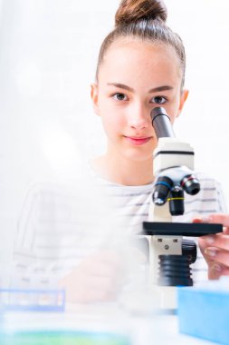 Kimya dersinde deneylerle ilgilenen genç bir kız öğrenci..