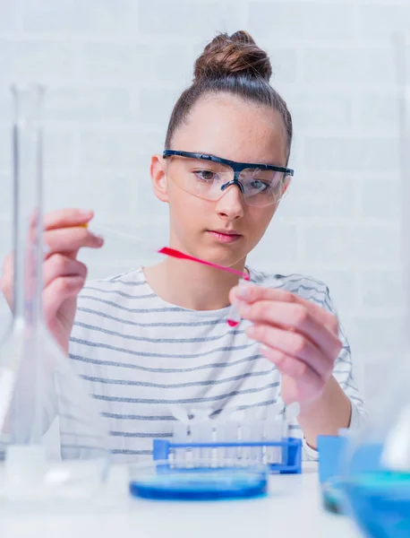 Tini lány diák gondoskodó kísérletek kémiai osztály. — Stock Fotó