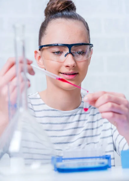 Tini lány diák gondoskodó kísérletek kémiai osztály. — Stock Fotó