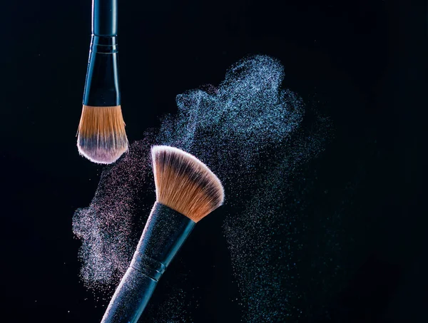 Make-up borstel met poeder explosie op zwarte achtergrond — Stockfoto