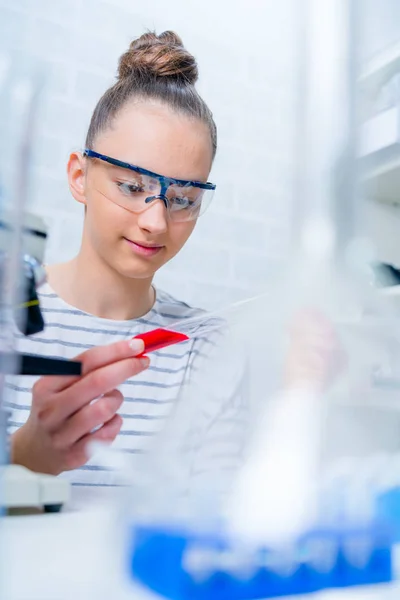 Tiener meisje student verzorgen experimenten in chemie klasse. — Stockfoto