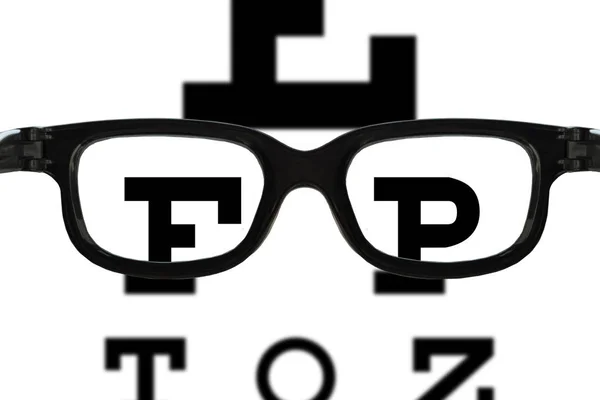 眼镜在视力测试图的前面与模糊和尖锐区域 — 图库照片