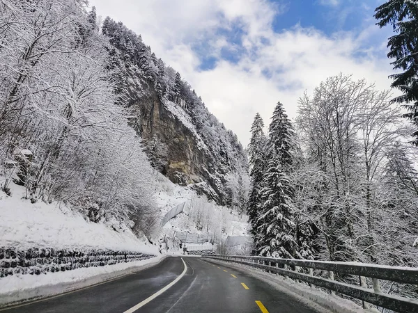 雪と雪に覆われた木々 に囲まれた覆われた滑らかな路面凍結曲線道路の状況を運転の美しい冬景色 — ストック写真
