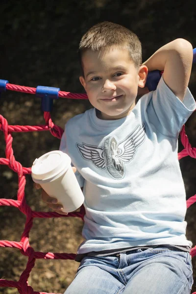 Niño Una Hamaca Con Una Taza Papel Bebida —  Fotos de Stock