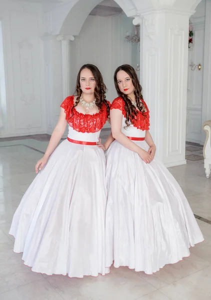 ホールのクリノリンと中世のドレスが白と赤の つの美しい女性 — ストック写真