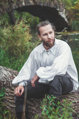 Ortaçağ kostüm ağaç açık oturma yakışıklı adam
